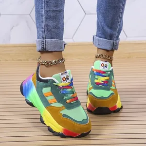 Vista ravvicinata di sneakers colorate con lacci arcobaleno e suola spessa su gambe di modella