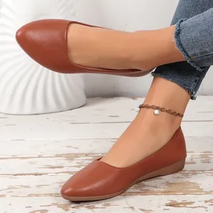 Detailed view of women's brown pointed-toe flat shoes with premium textured leather finish