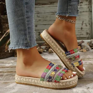 Detailansicht von ethnischen gewebten Plateau-Sandalen für Damen auf einem Holzdeck