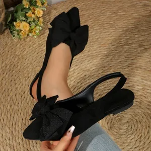 Vue de détail de ballerines slingback noires à bout pointu avec nœuds décoratifs