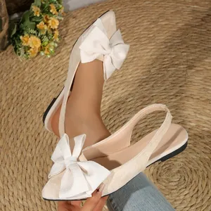 Vue détaillée d'élégantes ballerines beiges à bout pointu avec nœud décoratif