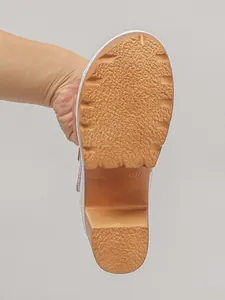 Detailopname van de slipvrije buitenzool met textuur en maatmarkering van een modieuze sleehak