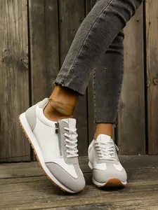 Detailed view of white and grey GAT sneakers with side zipper and gum sole