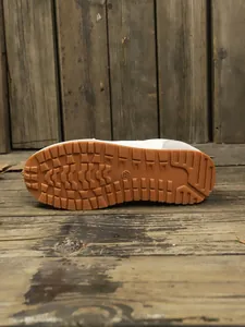 Detailed bottom view of durable brown rubber sole of women's casual sneakers with grip