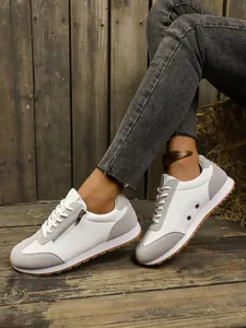 Side detail view of stylish white and grey lightweight women's sneakers with zipper