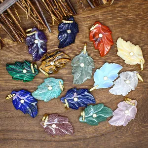 Detailed view of multiple leaf-shaped natural stone pendants with inlaid cubic zirconia