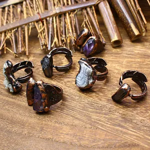 Group of vintage raw stone rings including amethyst and agate on a wooden background
