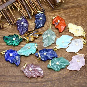 Detailed macro shot of diverse leaf-shaped natural stone pendants featuring inlaid zircon details