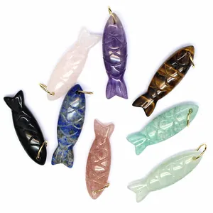 Detailed view of various colorful natural stone carved fish crystal pendants with gold loops