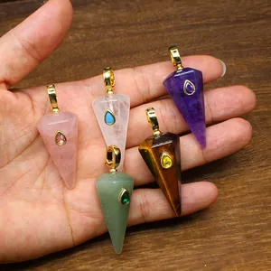 Close-up view of five hexagonal natural stone cone pendants held in hand for scale.