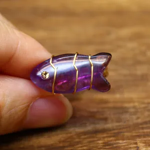 Macro view of handmade wire-wrapped fish-shaped amethyst ring with intricate golden detail