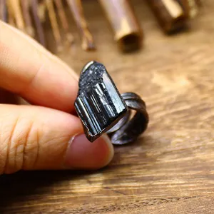 Detail view of raw black tourmaline crystal ring with vintage textured band