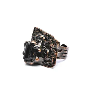 Detailed view of a vintage bronze ring with a raw black natural stone centerpiece