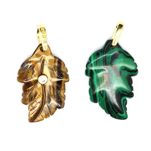 Close-up of natural stone leaf pendants in tiger's eye and malachite with zircon.