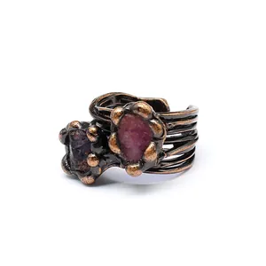 Macro view of a vintage bronze open ring set with natural raw reddish-purple crystals