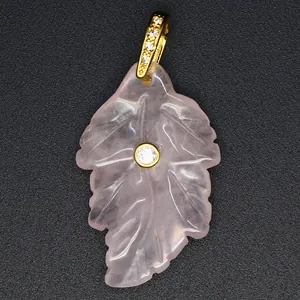 Close-up view of a natural rose quartz leaf pendant featuring a gold-toned bail and inset zircon