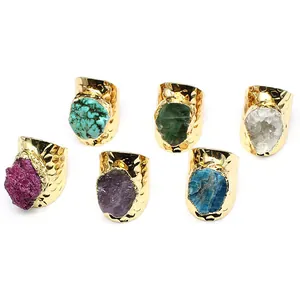 Detailed view of wide-band hammered gold rings featuring various colorful natural raw stones.