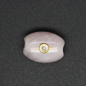 Close-up of pink strawberry quartz barrel bead with a central sparkling zircon inlay
