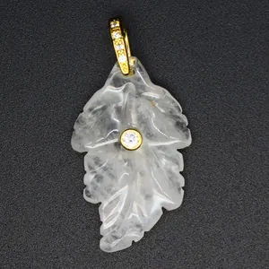 Close-up of a carved translucent crystal leaf pendant with gold-plated zircon inlay