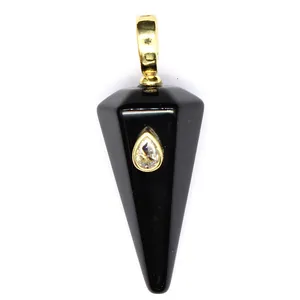 Detailed macro view of black hexagonal conical stone pendant with teardrop crystal inlay