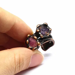 Detailed macro view of a vintage bronze open ring set with raw purple amethyst stones