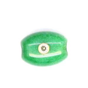 Macro view of green natural stone barrel bead with centered sparkling zircon inlay