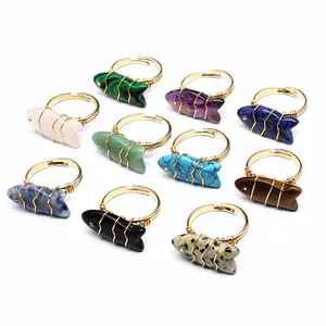 Detail of handmade wire-wrapped rings with fish-carved natural stones in various colors