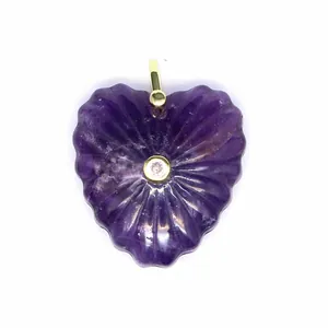 Dettaglio di un ciondolo in ametista a forma di cuore con zircone centrale.