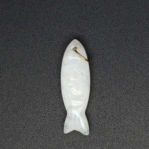 Detailed close-up showing hand-carved details of a white natural stone fish pendant charm.