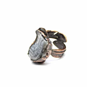 Close-up of a natural agate druzy gemstone ring with a vintage copper feather band