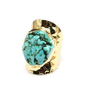 Detailed view of a bohemian gold wide band ring featuring a raw turquoise stone