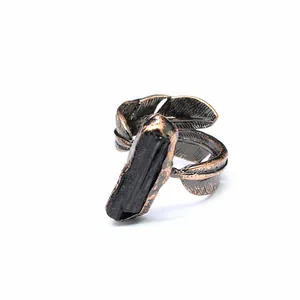 Detailed view of raw black tourmaline stone on bronze-tone feather shaped ring