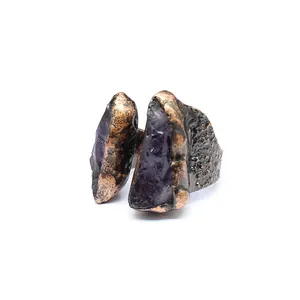Detailed view of a unique raw amethyst stone set in a rustic textured metal ring band