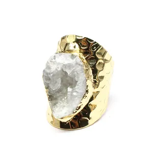 Detailed view of white druzy crystal stone set on a hammered gold-plated wide band