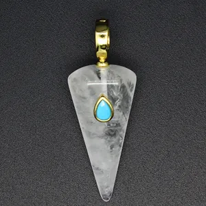 Close-up of white crystal cone pendant with turquoise inlay and gold bail
