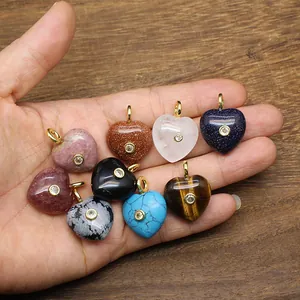 Lot de pendentifs cœur en pierre naturelle avec incrustation de zircon étincelant en main.