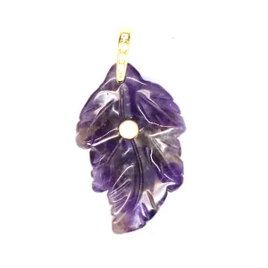 Detailed view of hand-carved purple amethyst leaf pendant with golden zircon inlay