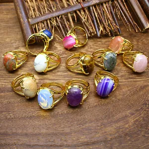 Collezione di anelli placcati oro 24k con varie pietre naturali su fondo di legno
