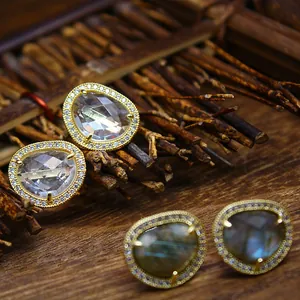 Macro view of Baroque style gold-plated earrings with micro-paved crystals and natural stones