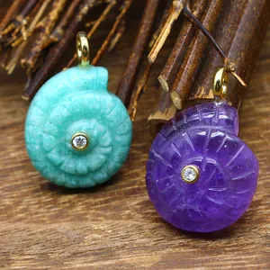Detail view of carved natural stone nautilus shell pendants with central zircon inlay