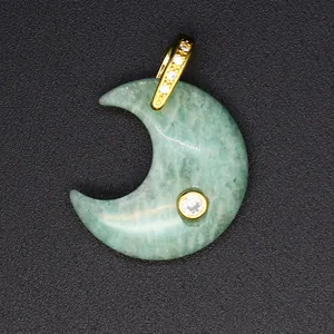 Close-up of a green natural stone moon pendant with gold bail and zircon inlays.