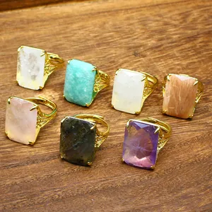 Detailed view of multiple rectangular faceted natural stone rings with adjustable gold bands