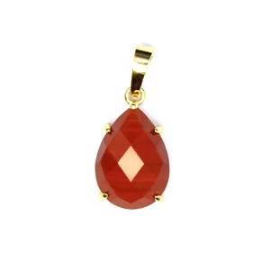 Vue détaillée d'un pendentif en pierre naturelle rouge à facettes avec une bélière dorée