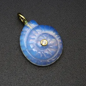 Detailed macro view of a carved opalite nautilus shell pendant featuring a zircon center.