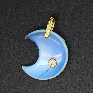 Close-up of a blue natural stone crescent moon pendant with gold-plated zircon inlay.