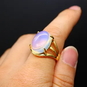 Dettaglio di un anello di lusso placcato oro con pietra ovale cangiante in stile opale