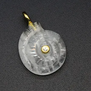 Detailed view of hand-carved crystal nautilus shell pendant with gold bail and zircon.