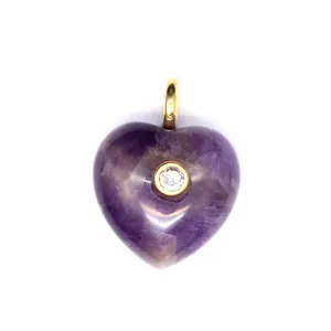 Vue détaillée d'un pendentif cœur en améthyste violette avec un zircon étincelant au centre.