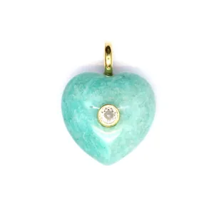 Détail macro d'un pendentif en pierre naturelle turquoise en forme de cœur serti de zircon