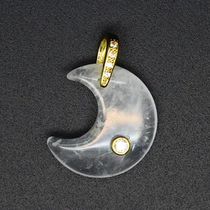 Detailed macro shot of a crescent moon shaped natural stone pendant with gold zircon bail